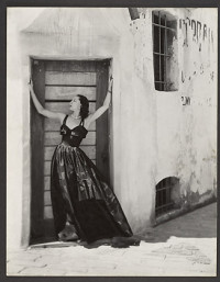 [Woman in Long Dress, Standing in Doorway of Stuccoed Building] (1930s-50s)