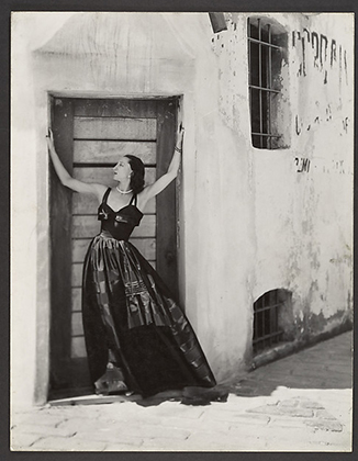 [Woman in Long Dress, Standing in Doorway of Stuccoed Building] (1930s-50s)